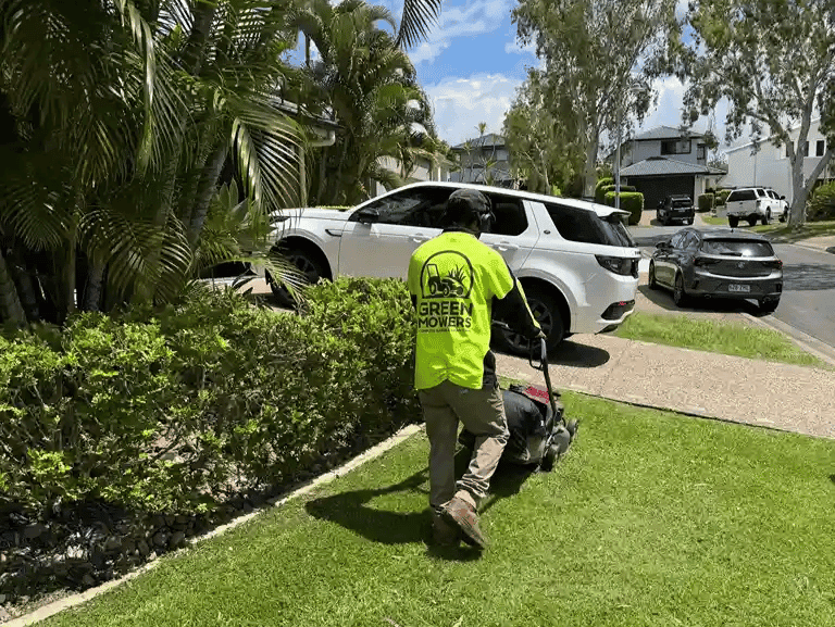 Green Mowers team member mowing a residential lawn